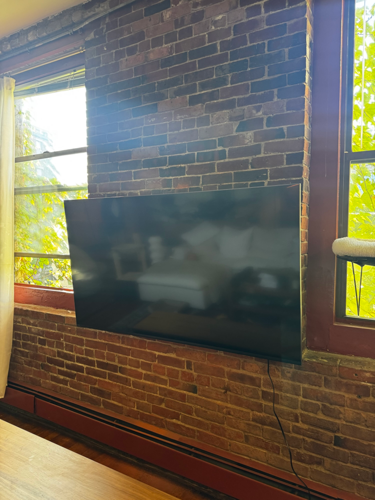 Wall-mounted television on an interior brick wall