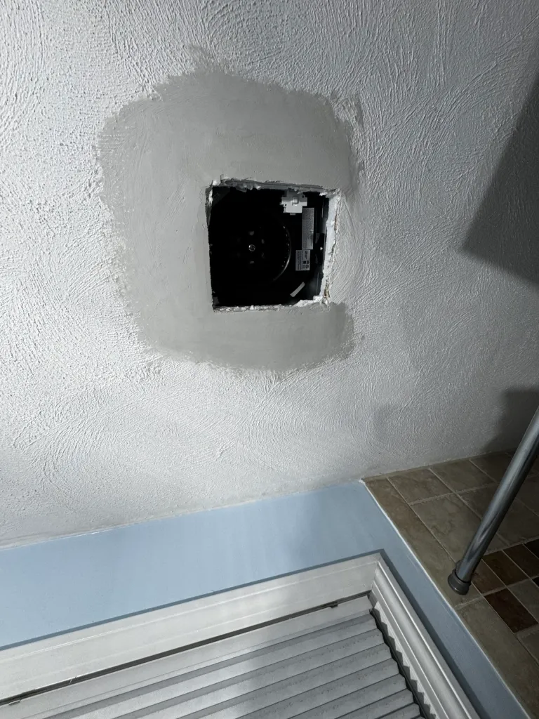 Wall repair opening patched around an electrical box
